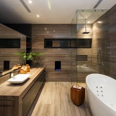 a bathroom with a large white tub sitting next to a walk in shower and sink