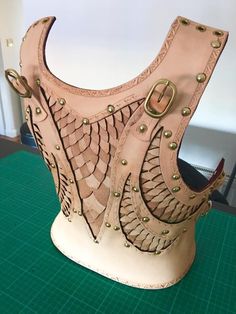 a leather corset is sitting on a green table