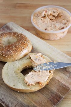 a bagel on a cutting board with a knife in it