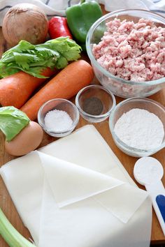 the ingredients are laid out on the cutting board to be used in this recipe, including carrots, celery, and meat