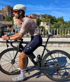 a man riding on the back of a bike next to a fire hydrant in front of a city