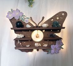 a wooden clock with butterflies and flowers on it