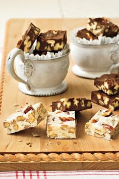 several pieces of dessert sitting on top of a wooden cutting board