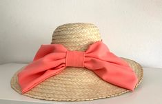 Straw hat with medium top and large brimmes with a soft downward fall that gives it a very elegant touch. It is adorned with ribbon and a large front loop. Chic Hats With Bow And Curved Brim, Short Brim Boater Hat With Bow For Garden Party, Chic Boater Hat With Ribbon For Beach, Brimmed Boater Hat With Bow For Kentucky Derby, Chic Brimmed Boater Hat With Bow, Boater Hat With Bow For Kentucky Derby, Brimmed Boater Hat With Bow For Garden Party, Chic Boater Hat With Curved Brim And Bow, Chic Boater Hat With Bow And Curved Brim