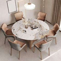 a round marble table with beige chairs around it and a white lamp hanging above the table