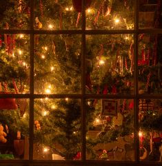 a christmas tree is seen through a window