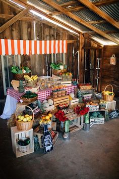 an assortment of fruits and vegetables on display in a barn with orange striped awnings