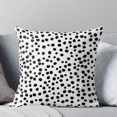 a black and white polka dot pattern on a pillow sitting on top of a couch