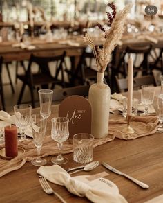 a wooden table topped with lots of glasses and plates