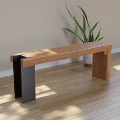 a wooden bench sitting on top of a hard wood floor next to a potted plant