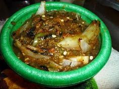 a green bowl filled with food sitting on top of a table next to a napkin