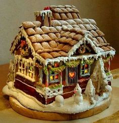 two pictures of a gingerbread house with candy on the roof