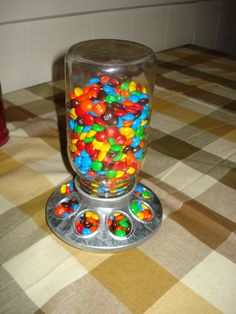 there is a gummy machine on the table next to a can of sodas