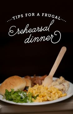 a white plate topped with macaroni and cheese next to a bun on a table