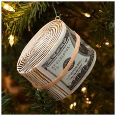 an ornament made out of rolled up money hanging from a christmas tree branch