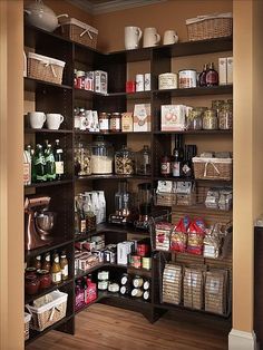 a pantry with lots of food and drinks on it's shelving unit in an orange walled room