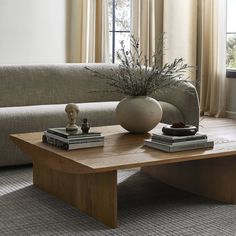 a coffee table with two books and a vase on it