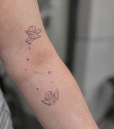 a small tattoo on the arm of a person with a teddy bear and stars around it