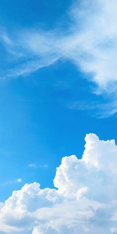 the airplane is flying high in the blue sky with white clouds behind it and an airplane on the right side