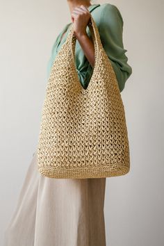 a woman is holding a straw bag in her hands