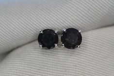 These black diamond earrings feature a pair of genuine earth mined diamonds that have been enhanced by irradiation to make them a fancy black color.  The diamonds contain some surfaces blemishes which are normal and expected to be seen in real black diamonds.  The settings are solid sterling silver.  The earrings have been appraised by a gemologist and the appraisal will be included with the earrings. The diamonds are described in the appraisal as follows: Shape And Cut: Round Brilliant Weight: Luxury Black Diamond Earrings For Anniversary, Luxury Black Round Diamond Earrings, Fine Jewelry Black Diamond Round Earrings, Black Round Diamond Earrings For Anniversary, Black Diamond Cut Round Earrings, Classic Black Diamond Earrings For Anniversary, Formal Round Black Diamond Earrings, Black Diamond Earrings For Anniversary, Formal Black Diamond Round Earrings