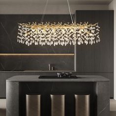 an elegant chandelier hanging over a kitchen island