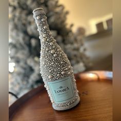 a bottle of wine sitting on top of a wooden table next to a christmas tree