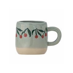 a ceramic mug with cherries painted on it