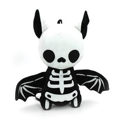 a small stuffed animal with a skeleton on it's chest and wings, sitting in front of a white background