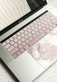 an open laptop computer sitting on top of a white marble countertop covered in frosting