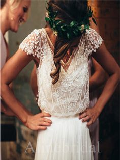 a woman wearing a flower crown standing in front of a man with his back to the camera