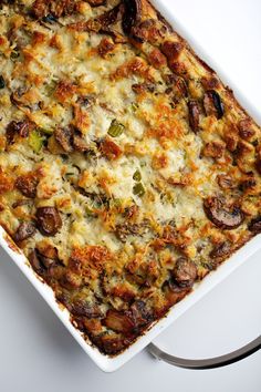 a casserole dish with sausage and broccoli in it on a white surface