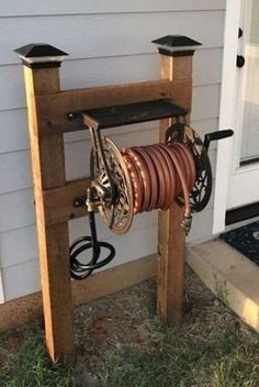 an old spool is being used to make a garden hose holder for the front door