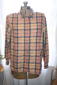 "size: medium - large Maker: Liz Claiborne. 100% cotton. Soft comfortable plaid blouse. Women's checkered shirt. Has 2 pockets in front. Colors are orange, blue, peach, coral shades. In good condition. Style: boho, grunge, goth, punk, retro, hippie, nautical, mod, hipster. measurements (blouse laying flat): 26\" L bust: 21 1/2\"W sleeve: 22 1/2\" L x 7\"W" Retro Plaid Shirt For Fall, Retro Long Sleeve Plaid Shirt, Retro Plaid Flannel Top, Retro Plaid Flannel Shirt For Fall, Vintage Flannel Button-up Shirt, Vintage Plaid Cotton Shirt, Vintage Plaid Cotton Flannel Shirt, Vintage Plaid Long Sleeve Flannel Shirt, Vintage Plaid Button-up Flannel Shirt