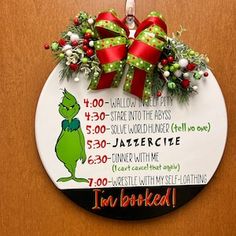 the grinch christmas ornament is hanging on a door with red and green bows