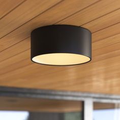 a black lamp hanging from a wooden ceiling