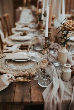 the table is set with plates and candles