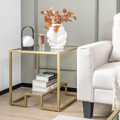 a living room with a white chair and gold side table