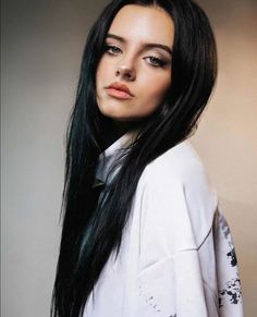 a woman with long black hair wearing a white shirt