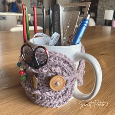 a coffee cup with some crocheted items in it