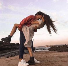 a man and woman kissing on the beach