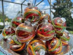 a glass bowl filled with christmas ornaments on top of a table