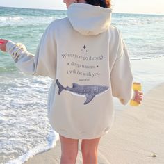 Dive into comfort and inspiration with our Whale Shark Hoodie featuring the powerful words of Isaiah 43:2: "When You Go Through Deep Waters, I Will Be With You." Crafted for ocean lovers, this hoodie embodies strength and support during life's challenges. Made with soft, cozy fabric and adorned with a majestic whale shark design, it's more than just a hoodie--it's a reminder of resilience and the boundless beauty of the ocean. Wear it proudly as you navigate life's currents and advocate for ocea Ocean Sweatshirt, Isaiah 43 2, Shark Sweatshirt, Shark Hoodie, Whale Shirt, Biblical Verses, Whale Shark, Deep Water, Oversized Style