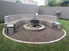 an outdoor fire pit in the middle of a yard with rocks and gravel around it