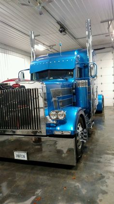 a blue semi truck parked in a garage