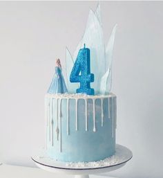 a blue frosted cake with icing and a figure on top that says 4