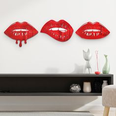 three red lips are hanging on the wall