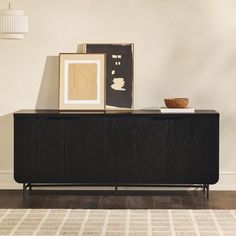 a sideboard with two framed pictures on it