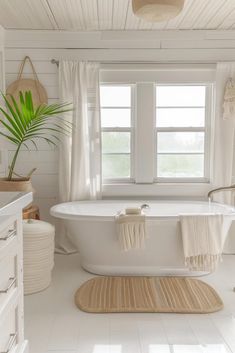 a bathroom with white walls and floors has a large bathtub in the middle of the room