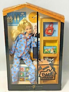 a barbie doll in pajamas is standing next to a book shelf